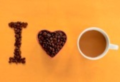 9556545-heart-shape-made-from-coffee-beans-with-a-cup-of-coffee-spelling-i-love-coffee