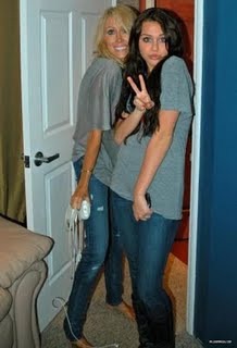 Miley Cyrus gray shirt, tight jeans, boots posing with mom in personal pic1 - Me