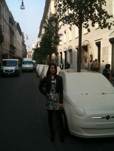 A pic of me with a car that\'s a planter! Fake cars are lining the streets with little trees coming 